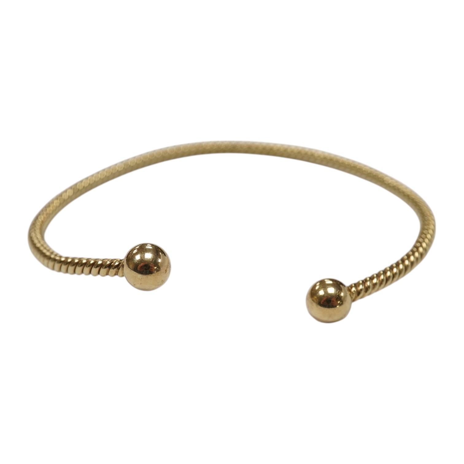 A modern 9ct gold open work bangle, with spherical terminals, 8.4 grams. Condition - fair